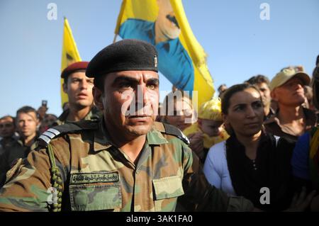 18. Oktober 2009 - Zakho, Irak - Ein kurdischer Peschmerga-Soldat versucht, die Menge der Unterstützer zu kontrollieren, die nach Zakho gekommen waren, um acht PKK-Geurillas bei einem friedensmarsch in die Türkei zu unterstützen. Acht kurdische Rebellen sind vom Irak aus in die Türkei eingedrungen, um sich als Zeichen der Unterstützung für Friedensbemühungen aufzugeben. Die PKK-Militanten verließen ihre Zuflucht in den Qandil-Bergen und wurden von Flüchtlingen aus dem Flüchtlingslager Makmur im Irak begleitet, bevor sie in die Türkei einreisten. (Kreditbild: © Kamaran Najm/ZUMA Press) Stockfoto