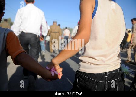 18. Oktober 2009 - Zakho, Irak - zwei kurdische irakische Jungen gehen Hand in Hand an die Grenze zur Türkei. Acht kurdische Rebellen sind vom Irak aus in die Türkei eingedrungen, um sich als Zeichen der Unterstützung für Friedensbemühungen aufzugeben. Die PKK-Militanten verließen ihre Zuflucht in den Qandil-Bergen und wurden von Flüchtlingen aus dem Flüchtlingslager Makmur im Irak begleitet, bevor sie in die Türkei einreisten. (Kreditbild: © Kamaran Najm/ZUMA Press) Stockfoto