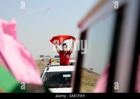 18. Oktober 2009 - Zakho, Irak - ein irakischer Kurde hält die kommunistische PKK-Flagge hoch, während er an die Grenze zur Türkei fährt. Acht kurdische Rebellen sind vom Irak aus in die Türkei eingedrungen, um sich als Zeichen der Unterstützung für Friedensbemühungen aufzugeben. Die PKK-Militanten verließen ihre Zuflucht in den Qandil-Bergen und wurden von Flüchtlingen aus dem Flüchtlingslager Makmur im Irak begleitet, bevor sie in die Türkei einreisten. (Kreditbild: © Kamaran Najm/ZUMA Press) Stockfoto