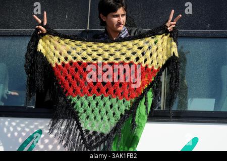18. Oktober 2009 - Zakho, Irak - ein irakischer Anhänger der PKK hält einen Schal hoch, der mit den Farben der kurdischen Flagge bestickt ist. Acht kurdische Rebellen sind vom Irak aus in die Türkei eingedrungen, um sich als Zeichen der Unterstützung für Friedensbemühungen aufzugeben. Die PKK-Militanten verließen ihre Zuflucht in den Qandil-Bergen und wurden von Flüchtlingen aus dem Flüchtlingslager Makmur im Irak begleitet, bevor sie in die Türkei einreisten. (Kreditbild: © Kamaran Najm/ZUMA Press) Stockfoto