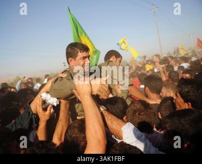 18. Oktober 2009 - Zakho, Irak - einer der PKK-Guerillas auf dem Weg zur türkischen Grenze wird von der unterstützenden Menge hochgehalten. Acht kurdische Rebellen sind vom Irak aus in die Türkei eingedrungen, um sich als Zeichen der Unterstützung für Friedensbemühungen aufzugeben. Die PKK-Militanten verließen ihre Zuflucht in den Qandil-Bergen und wurden von Flüchtlingen aus dem Flüchtlingslager Makmur im Irak begleitet, bevor sie in die Türkei einreisten. (Kreditbild: © Kamaran Najm/ZUMA Press) Stockfoto