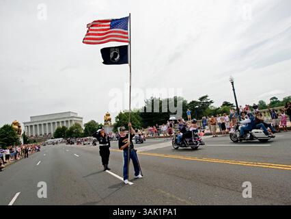 24. Mai 2009 – Washington, District of Columbia, USA – JIM CLOYES steht auf der Bühne und grüßt, als PAUL STANCLIFF am Sonntag, den 24. Mai 2009, einen 15-Fuß-Stab mit riesigen amerikanischen und Kriegsgefangenenflaggen am Ende zeigt, während Rolling Thunder Motorradfahrer über die Memorial Bridge in Washington D.C. brüllen. Seit 19 Jahren ist Stancliff an jedem Memorial Day-Wochenende ein wichtiger Bestandteil des Memorial Day Motorcycle Remember Ride. (Foto: © Pete Marovich/ZUMA Press) Stockfoto