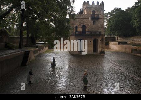 19. Juli 2012 - Mauritius - Fasilides' Bath, Gondar, Äthiopien. Durch eine alte hölzerne Tür, in der ein freundlicher alter Mann, der anscheinend der „Wächter“ des Ortes zu sein scheint, schläft, nach einem kurzen Gespräch betreten wir das Gehege, vor unseren Augen befindet sich ein kleines Gebäude im „Gondarino-Stil“, in dem Ein Paar Türme aus zwei Pflanzen hervorragen, zu Füßen des Gebäudes öffnet sich ein Teich oder ein „Pool“ von etwa 3.000 Quadratmetern, es sind die berühmten Bäder Kaiser Fasilidas. Das Holz im Gehege, das sich der Schönheit des Ortes bewusst ist, verschmilzt mit dem Stein der Mauer, die den Teich umgibt, Achiev Stockfoto