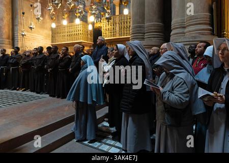 Römisch-katholische Nonnen rezitieren Gebete, während sie an einer Prozessionsmesse in der Grabeskirche in der Altstadt von Jerusalem teilnehmen. Israel. Die Grabeskirche ist der traditionelle Ort sowohl von Golgatha (Kalvaria) als auch von Jesu Grab. Kaiser Konstantin errichtete im 4. Jahrhundert die erste Kapelle an der Stelle, nachdem seine Mutter Helena den Ort identifiziert hatte. Stockfoto