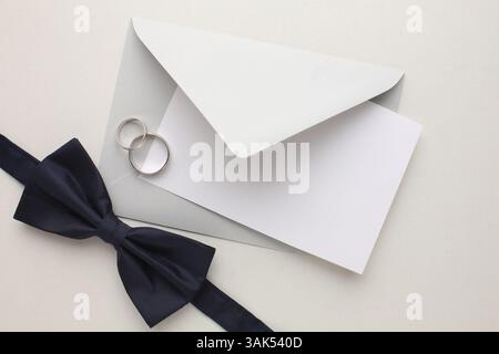 Elegante Hochzeitszubehör für den Bräutigam – Parfüm, Fliege, Boutonniere und Hochzeitsringe auf hellem Hintergrund. Hochwertige Fotos Stockfoto