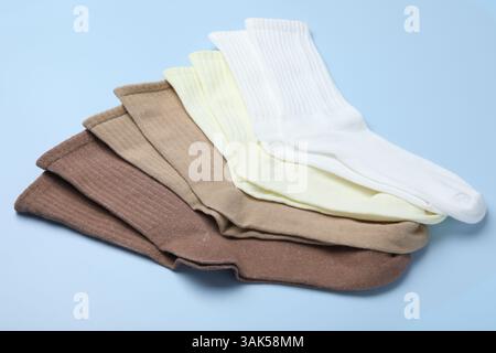 Viele verschiedene Paar Socken auf hellblauem Hintergrund, Nahaufnahme Stockfoto