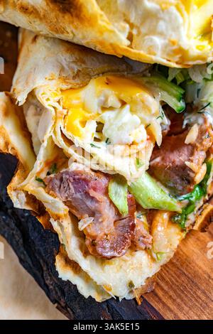 Köstlicher Burrito mit gegrilltem Fleisch und frischem Gemüse Stockfoto