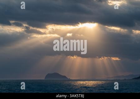 Erleben Sie den faszinierenden Tanz der Wolken und des Sonnenlichts über dem Ozean an einem Frühlingsmorgen und fangen Sie den atemberaubenden Blick auf Keelung Island von Jinshan ein Stockfoto