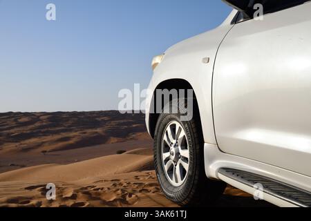 Rub Al Khali Wüste, Sultanat Oman - 5. April 2025: Geländewagen auf der Dünenspitze in der Wüste Wahiba Sands bei Sonnenuntergang, Arabische Halbinsel Stockfoto