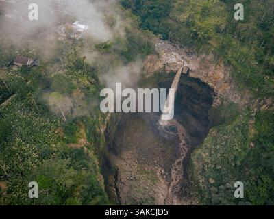 Aus der Vogelperspektive eines majestätischen Wasserfalls, der sich in eine üppige bergige Schlucht in Indonesien stürzt Stockfoto