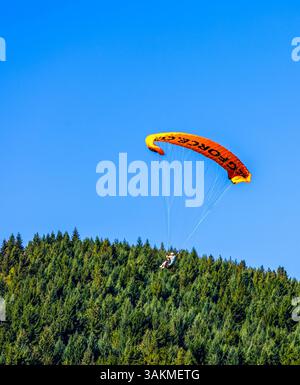Queenstown, Neuseeland - 28. Februar 2025: Tandem-Gleitschirmfliegen über die Bäume in Queenstown, Südinsel, Neuseeland Stockfoto