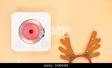 Weißer tragbarer CD-Player mit roten Kopfhörern auf beigefarbenem Hintergrund. Stockfoto