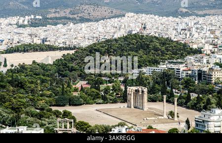 Die Ruinen eines antiken Tempels in Athen von der Akropolis aus gesehen, mit dem Panathenaic-Stadion und der Stadt auf der Rückseite. Stockfoto