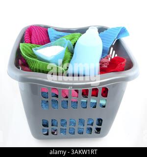 Wäschekorb gefüllt mit bunten Handtüchern isoliert über weiß Stockfoto