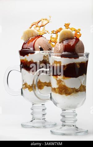 Caramel und Schokolade parfait Dessert mit Sahne und Eis gekrönt mit knusprigem Karamell und in hohen Gläsern für ein Gourmet Dessert Stockfoto