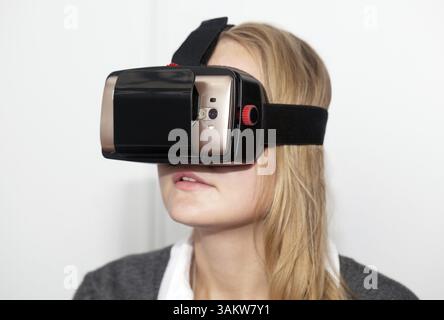 Nahaufnahme einer jungen Frau VR-Headset mit Smart Phone. Erste Schritte in den virtuellen Raum mit modernen Technologien Stockfoto
