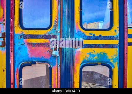 Verwitterte bunte Metalltür mit Vorhängeschloss in Nelson Nevada Stockfoto