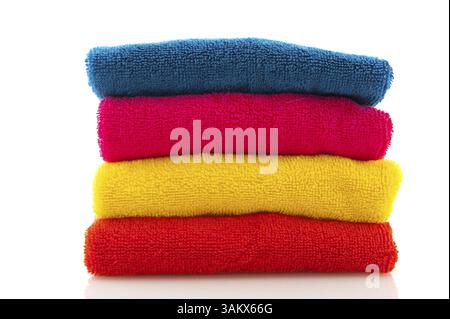 Stapeln Sie mit bunten gefalteten Handtüchern, die über weiß isoliert sind Stockfoto