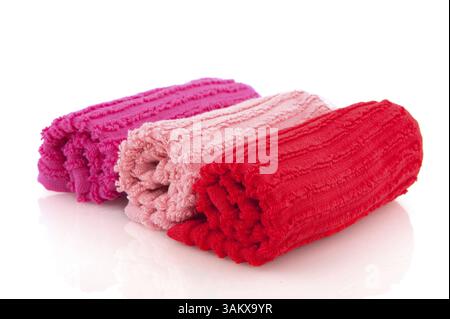 Gerollte Handtücher in rosa und rot über weiß isoliert Stockfoto