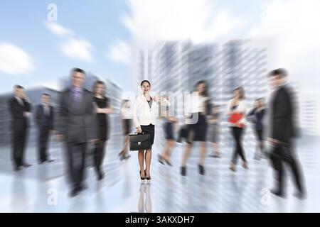 Im Stadtzentrum auf der Straße verschwimmerten Menschen mit einer jungen Geschäftsfrau Stockfoto