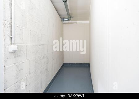 Kleiner Versorgungslagerraum mit Lüftungsrohr und Betonwänden Stockfoto