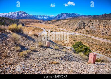 Wüstenlandschaft mit schneebedeckten Bergen und Blick auf die Straße auf Augenhöhe Stockfoto