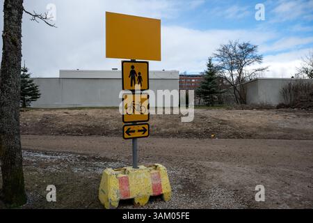 Gelbes Wegweiser für Fußgänger und Radwege auf einem Feldweg auf der Baustelle Stockfoto