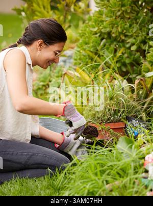 Gartenarbeit, Frühling und Frau mit Blumen im Garten für natürliche Umwelt, Wachstum und Ökosystem. Natur, Gärtner und Mensch, der Samen pflanzt, Bäume Stockfoto