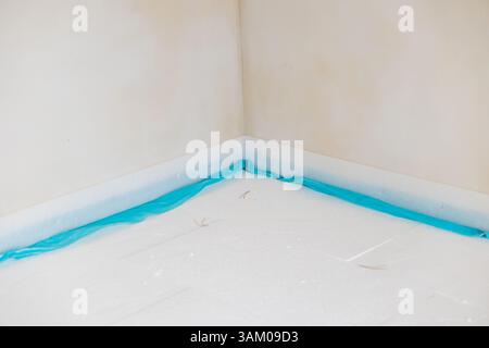 Arbeiter, die Polystyrol-Dämmplatten installieren und mit Schutzfolie abdecken Stockfoto