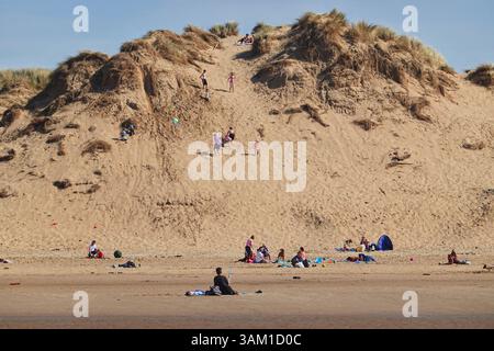 Die Menschen genießen einen sonnigen Tag am Meer an einem Strand von Formby in Großbritannien Stockfoto