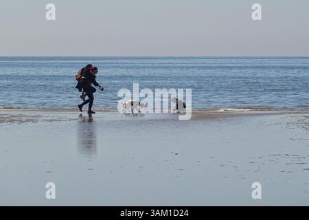 Die Menschen genießen einen sonnigen Tag am Meer an einem Strand von Formby in Großbritannien Stockfoto