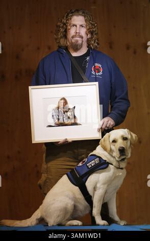 12. Februar 2014 - Gilroy, CA, USA - Jeffrey Wilson mit seinem Diensthund Selah, einem 23 Monate alten gelben Labrador-Retriever während des Trainings in der Operation Freedom Paws' Trainingsanlage in Gilroy, Kalifornien, am 12. Februar 2014. Wilson hält ein Foto seines ehemaligen Diensthundes Lobo, der im August 2013 bei einem Unfall ums Leben kam. (Kreditbild: © Josie Lepe/MCT/ZUMAPRESS.com) Stockfoto