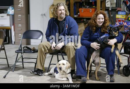 12. Februar 2014 - Gilroy, CA, USA - Jeffrey Wilson und sein Diensthund Selah, ein 23 Monate alter Labrador Retriever, sitzen mit seiner Frau Gwen Templeton und ihrem Diensthund Ellie, einer 23 Monate alten Doberman/Labrador-Mischung, am 12. Februar 2014 in der Ausbildungseinrichtung der Operation Freedom Paws in Gilroy, Kalifornien. (Kreditbild: © Josie Lepe/MCT/ZUMAPRESS.com) Stockfoto