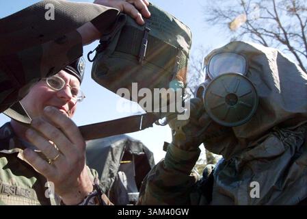 11. Februar 2003 - USA - KRT US NEWS STORY SLUGGED: MILITÄRISCHES KRT FOTO VON ROBIN TRIMARCHI/COLUMBUS LEDGER-ENQUIRER (11. Februar) FORT BENNING, GA--- SPC Ralph Kiesler aus Huntsville, Alabama, hilft SPC. Januar Racca aus Connecticut bleibt während eines Tages der Dekontaminationsübungen am Dienstag, 11. Februar 2003, in Fort Benning, Georgia, Georgia, hydratisiert. Beide sind Reservisten bei der 318th Chemical Company of Birmingham, Alabama, und wurden am 9. Januar, nur drei Tage nach der Deaktivierung von einem Jahr im Dienst nach den Terroranschlägen vom 11. September 2001, aktiviert. (lde) 2003 (Kreditbild: © Rob Stockfoto