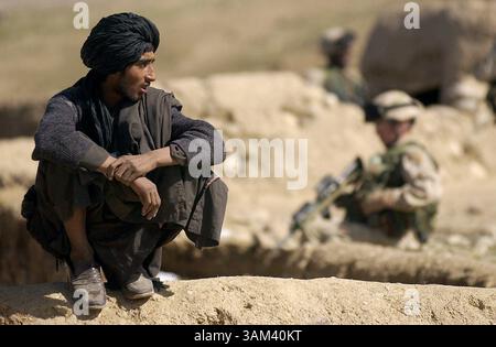 19. Februar 2003 - USA - KRT WORLD NEWS STORY SLUGGED: AFGHANISCH-US KRT FOTO VON DAVID SWANSON/PHILADELPHIA INQUIRER (21. Februar) ein Afghan beobachtet, wie Soldaten von der 82. Luftlandedurchsuchung sein Dorf, 20. Februar 2003. Im Baghran-Tal südlich des Helmond-Flusses stürzten Truppen in der Operation Viper ab, eine Operation, die voraussichtlich drei Wochen dauern wird, während Soldaten von Dorf zu Dorf und Haus zu Haus ziehen, um nach militärischem Material und Anzeichen von Taliban- und Al-Qaida-Sympathisanten zu suchen. (lde) 2003 (Bild: © Philadelphia Inquirer/mct/ZUMAPRESS.com) Stockfoto