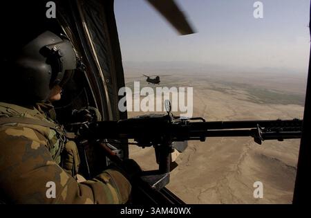 19. Februar 2003 - USA - KRT WORLD NEWS STORY SLUGGED: AFGHANISCH-US KRT FOTO VON DAVID SWANSON/PHILADELPHIA INQUIRER (21. Februar) Ein Seitenschützer auf einem Chinook 47 blickt über Helmand, Afghanistan auf einem Rückflug zur Kandahar Air Base, 21. Februar 2003. Im Baghran-Tal südlich des Helmond-Flusses stürzten Truppen in der Operation Viper ab, eine Operation, die voraussichtlich drei Wochen dauern wird, während Soldaten von Dorf zu Dorf und Haus zu Haus ziehen, um nach militärischem Material und Anzeichen von Taliban- und Al-Qaida-Sympathisanten zu suchen. (lde) 2003. (Kreditbild: © Philadelphia Inquirer/mct/ZUMAP Stockfoto