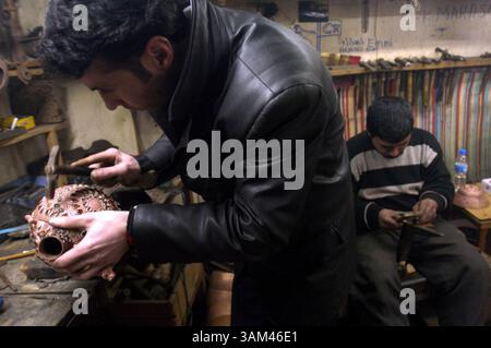 24. Februar 2004 - USA - KRT WORLD NEWS STORY SLUGGED: TÜRKEI-FLEAMARKETS KRT FOTO VON (März 31) Murat Omer, links, arbeitet in einer Kupferwerkstatt im Kapali Carsi (großer Basar) in Istanbul, Türkei, das kurz nach seiner Eroberung der Stadt 1453 von Megmet II. Gegründet wurde. Heute ist dieses Labyrinth von Straßen, die von bemalten Gewölben bedeckt sind, mit Tausenden von buschenähnlichen Geschäften gesäumt, in denen Sie Antiquitäten, Teppiche, Gold, Silber, Lederwaren und vieles mehr kaufen können. (nk) 2004 (Kreditbild: © Zbigniew Bzdak/mct/ZUMAPRESS.com) Stockfoto