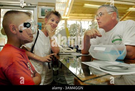 24. Juni 2004 - USA - KRT US NEWS STORY SLUGGED: ENV-OTD-WATERCAVES KRT FOTO VON DAVID ZENTZ/ORLANDO SENTINEL (MIAMI OUT) (1. Juli) Andy Grube, 10, versucht eine Schnorchelmaske, während seine Mutter Missy Grube und der Besitzer des West Dive Scuba Shops Paul Heinerth darüber diskutieren, wie sie aussieht. Heinerth und sein anderer Tauchlehrer Larry Green haben die Leichen von zwei Höhlentauchern geborgen, die im Höhlensystem Eagle's Nest starben. (cdm) 2004 (Bild: © David Zentz/mct/ZUMAPRESS.com) Stockfoto