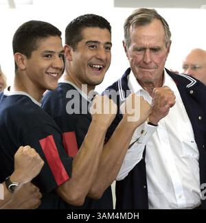 13. August 2004 - USA - KRT SPORTS STORY SLUGGED: OLY-BUSH KRT FOTO VON RON CORTES/PHILADELPHIA INQUIRER (13. August) ATHEN, GRIECHENLAND-- der ehemalige Präsident George Bush versucht, seine Muskeln mit Mark Lopez und Steven Lopez, US-Taekwondo-Teilnehmer zu bewegen, während sie ein Gruppenfoto am American College of Greece am Freitag machten. Präsident Bush und seine Frau Barbara trafen sich mit den Athleten, die an der Schule trainierten. Ag2004 (Kreditbild: © Ron Cortes/mct/ZUMAPRESS.com) Stockfoto