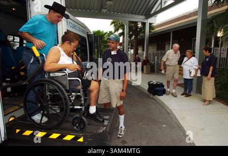 13. August 2004 - USA - KRT US-NEWS STORY SCHLEPPTE: WEA-STORMS KRT FOTO VON ED SACKETT/ORLANDO SENTINEL (13. August) ST CLOUD, FL-- Jose Juarbe, links, und Manny Custodio, beide zusammen mit dem Council on Aging, helfen Elba Batista, 60, aus dem Bus und in die Notunterkunft in St Cloud Freitag, 13. August 2004, in Vorbereitung auf Hurricaine Charley. (lde) 2004 (Bild: © Ed Sackett/mct/ZUMAPRESS.com) Stockfoto