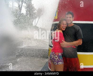 13. August 2004 - USA - KRT US-NEWS STORY SLUGGED: WEA-STÜRME KRT FOTO VON CHUCK FADELY/MIAMI HERALD (13. August) KEY WEST, FL-- Janet McNeilly und Shawn Thompson nehmen Zuflucht hinter dem südlichsten Marker in Key West, Florida, während Wellen, die von Hurrikan Charley getrieben werden, über sie stürzen, Freitagmorgen, 13. August 2004. (lde) 2004 (Bild: © Chuck Fadely/mct/ZUMAPRESS.com) Stockfoto