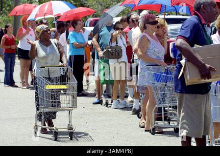 15. August 2004 - USA - KRT US NEWS STORY SLUGGED: WEA-STORMS KRT FOTO VON ROBIN TRIMARCHI/BRADENTON HERALD (15. August) PORT CHARLOTTE, FL -- die Bewohner warten am Sonntag, den 15. August 2004 auf Wasser, Eis und gespendete Lebensmittel in einem Einkaufszentrum in Port Charlotte, Florida. Hurrikan Charley verursachte schwere Schäden in der Gegend am 13. August 2004. (cdm) 2004 (Kreditbild: © Robin Trimarchi/mct/ZUMAPRESS.com) Stockfoto