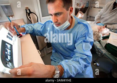 19. September 2004 - USA - KEINE MAGIE, KEINE VERKÄUFE -- KRT US-NEWS SCHLEPPTE: SRS-MED-ZAHNÄRZTE KRT FOTO VON MIKE SIEGEL/SEATTLE TIMES (3. Oktober) Dr. Hugh Gruhn überprüft Jean Hughes' Röntgenaufnahmen während einer Untersuchung im mobilen Dentalwagen. Der Van besucht einmal im Monat das Northshore Senior Center in Bothell, Washington. (nk) 2004. (Bild: © Mike Siegel/mct/ZUMAPRESS.com) Stockfoto