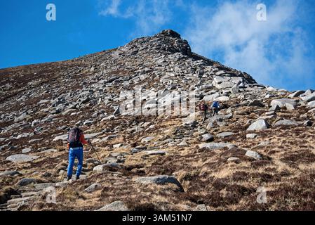 Junge Frau Bergwandererin direkt unterhalb des Gipfels von Goatfell auf der Isle of Arran, North Ayrshire, Schottland, Großbritannien. Stockfoto