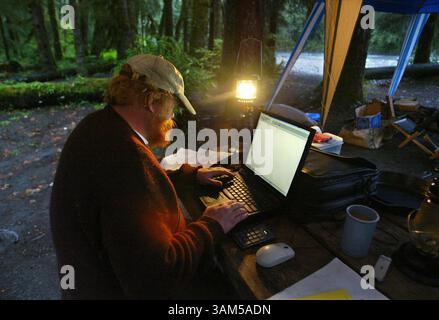 8. September 2004 - USA - KEINE MAGIE, KEINE VERKÄUFE -- KRT US-NEWS-STORY SCHLEPPTE: ENV-QUEETS KRT FOTO VON STEVE RINGMAN/SEATTLE TIMES (3. Februar) Robert Van Pelt sitzt an seinem Laptop, angetrieben von einer Bootsbatterie, um Daten vom Aufstieg des Vortages in das Walddach entlang des Queets River im Bundesstaat Washington aufzuzeichnen. (Mvw) 2005 (Bild: © Steve Ringman/mct/ZUMAPRESS.com) Stockfoto