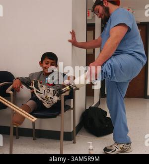 12. Januar 2005 - USA - KRT US NEWS STORY SLUGGED: MED-IRAQBOMBVICTIM KRT FOTO VON KAREN SCHIELY/AKRON BEACON JOURNAL (23. Mai) Majid Fadhil Sabor lächelt, während er am 24. Januar 2005 die Prothese des Labortechnikers Gabe Gullia bei Yanke Bionics in Akron, Ohio, anschaut. Majid wurde im Februar 2004 durch eine Bombe im Irak verletzt und erhielt in den Vereinigten Staaten eine Prothetik. (gsb) 2005 (Kreditbild: © Karen Schiely/mct/ZUMAPRESS.com) Stockfoto