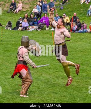 Dorchester, Dorset, Großbritannien. April 2025. Britannia Roman spielt eine Gladiator-Demonstration vor Zuschauern beim Dorchester Roman Festival in Maumbury Rings, Dorchester in Dorset. Die kostenlose Veranstaltung in Maumbury Rings, eine neolithische Henge, die von den Römern um 100 n. Chr. als Amphitheater genutzt wurde, ist Teil einer zweitägigen Veranstaltung, die während der Osterferien an verschiedenen Orten in der Stadt stattfindet. Bildnachweis: Graham Hunt/Alamy Live News Stockfoto
