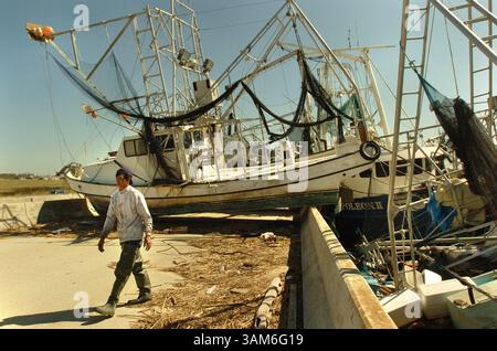 8. Okt. 2005 - USA - KRT US-NEWS STORY SCHLEPPTE: WEA-STORMS-MESS KRT FOTO VON NADER KHOURI/CONTRA COSTA TIMES (10. Oktober) Duc Nguyen geht von seinem Garnelenboot weg, das infolge der Hurrikane Katrina und Rita in der Stadt Empire in Plaquemines Parish, Louuisiana, am Samstag, 8. Oktober 2005 gegen die Überführung des Highway 23 gefegt wurde. Nguyen sagte, er hätte 3.000 Pfund Garnelen im Wert von 5.000 Dollar im Boot. Er hoffte, den Motor aus dem Boot retten zu können. (lde) 2005. (Abbildung: © Nader Khouri/mct/ZUMAPRESS.com) Stockfoto