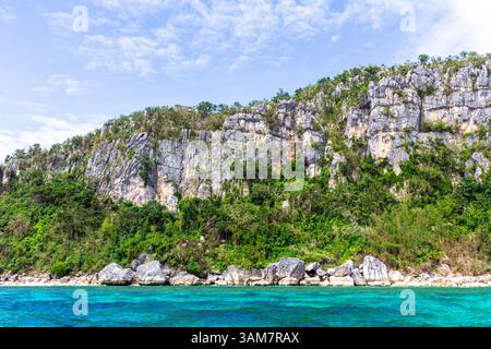 Blick auf die dramatischen Kalksteinkarstberge in Isla Gigantes, Iloilo, Philippinen, die sich über üppige tropische Vegetation und klaren blauen Himmel erheben Stockfoto