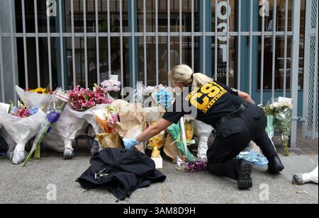 29. Juli 2006 - USA - Ein Tatortdetektiv ordnet Blumen vor dem Gebäude der jüdischen Föderation in Seattle, Washington, am Samstag, 20. Juli 3006. Eine Person war tot und fünf andere wurden am Freitag nach einer Schießerei im Gebäude der jüdischen Föderation von Greater Seattle in Downtown Seattle, Washington, von Naveed Haq ins Krankenhaus gebracht, der erklärte, er sei „wütend auf Israel“. (Alan Berner/Seattle Times/MCT) (Bild: © Alan Berner/mct/ZUMAPRESS.com) Stockfoto